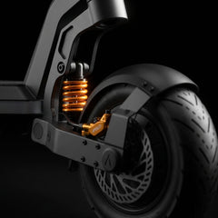 Close-up of an Apollo electric scooter rear wheel, showing the suspension spring and disc brake.